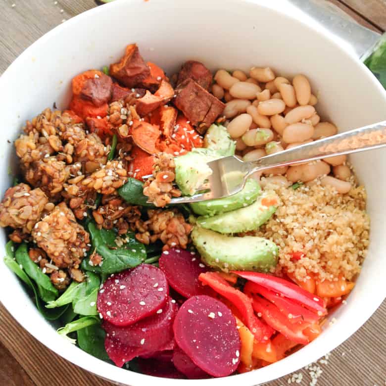 Vegan Quinoa Buddha Bowl in white bowl with quinoa, tempeh, avocado, beets, peppers, sweet potatoes