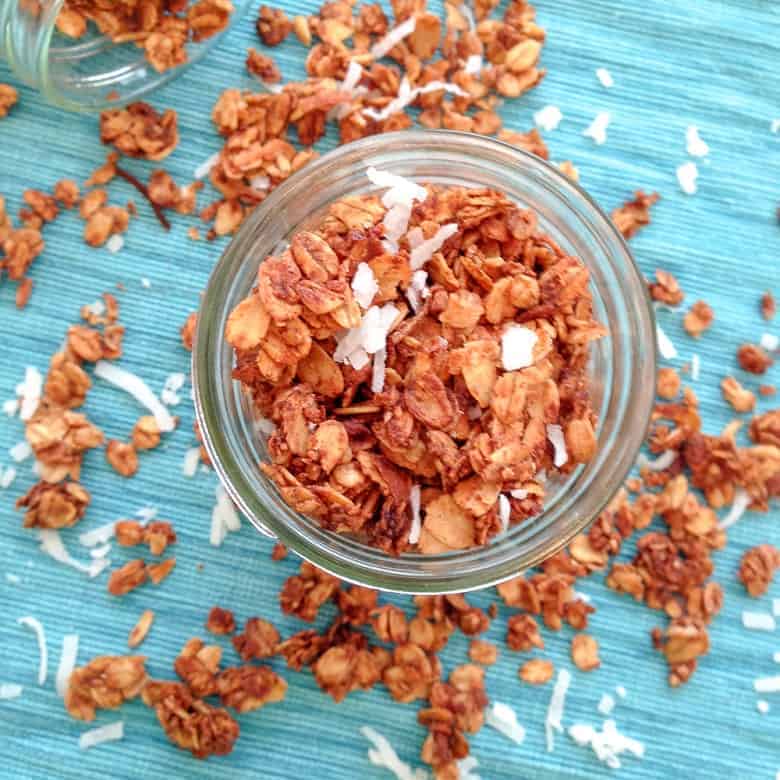 Overhead view of cinnamon maple granola with coconut flakes on blue mat | Bucket List Tummy