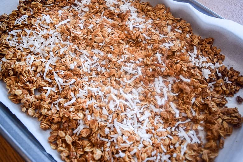 Sheetpan of homemade maple granola with coconut flakes