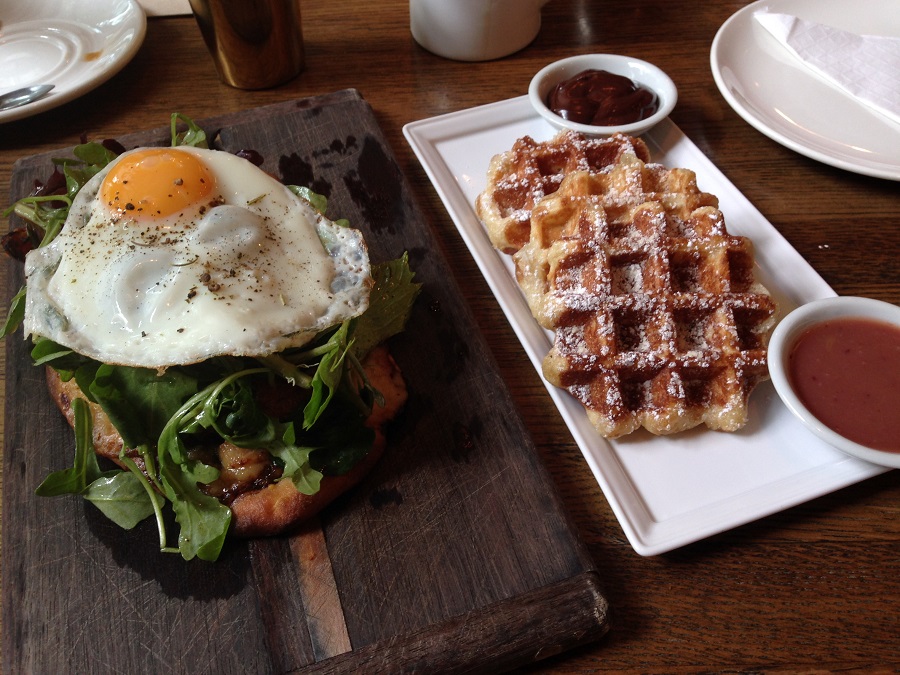 egg plate and liege waffles on white plate on restaurant table