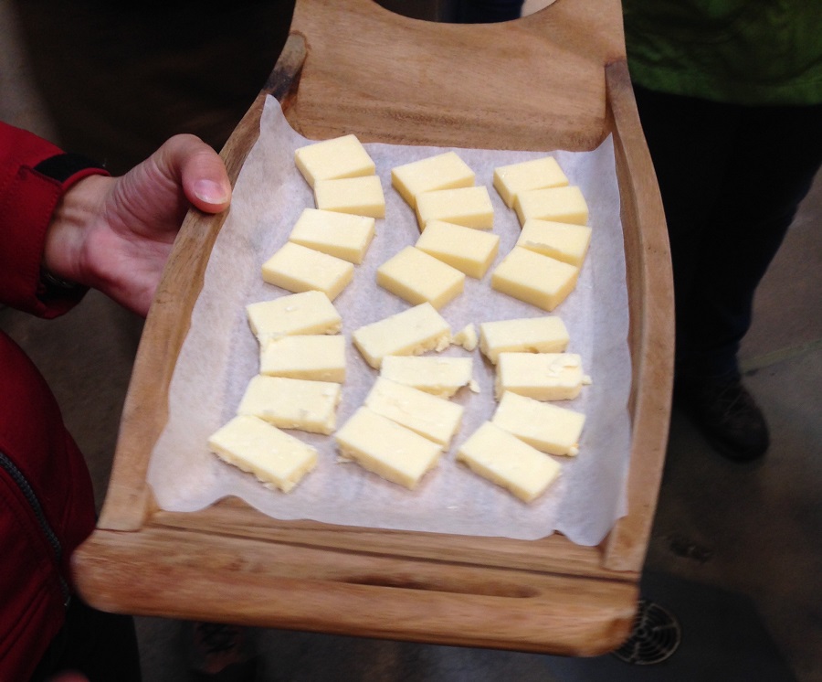 sliced cheese on wooden plate for tasting 