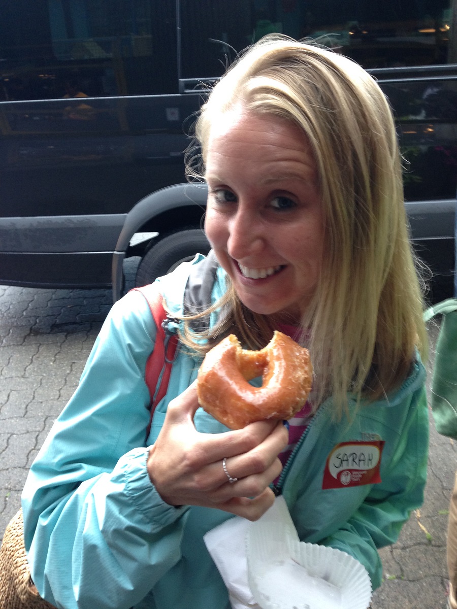 girl eating Lee's Donuts on Granville Island during food tour