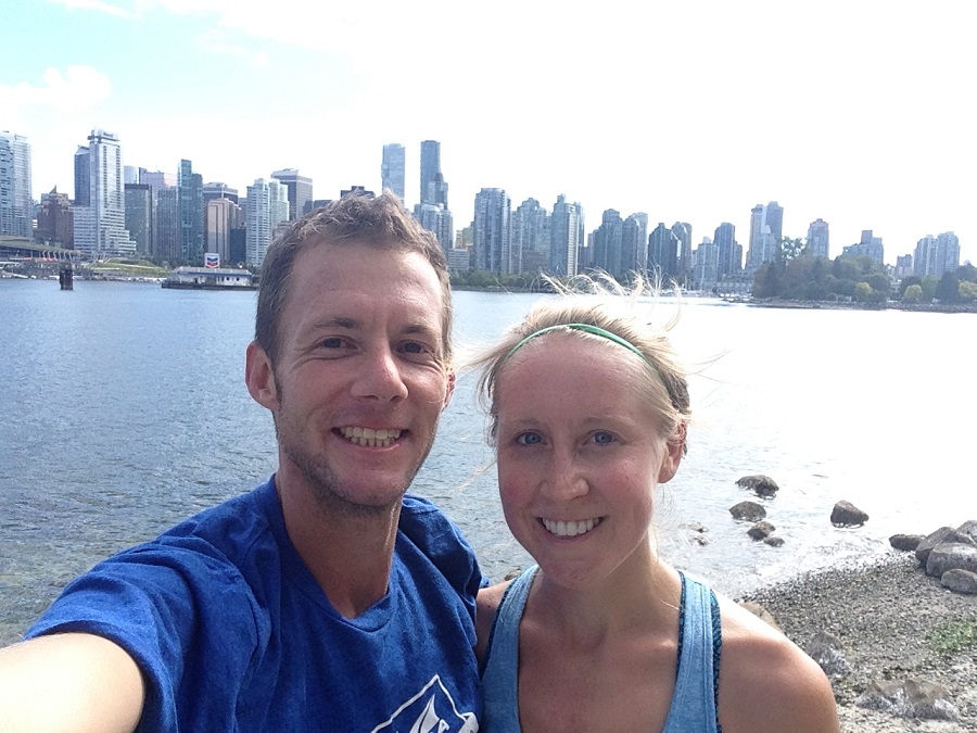 husband and wife posing for pictures on Vancouver Seawall during a run