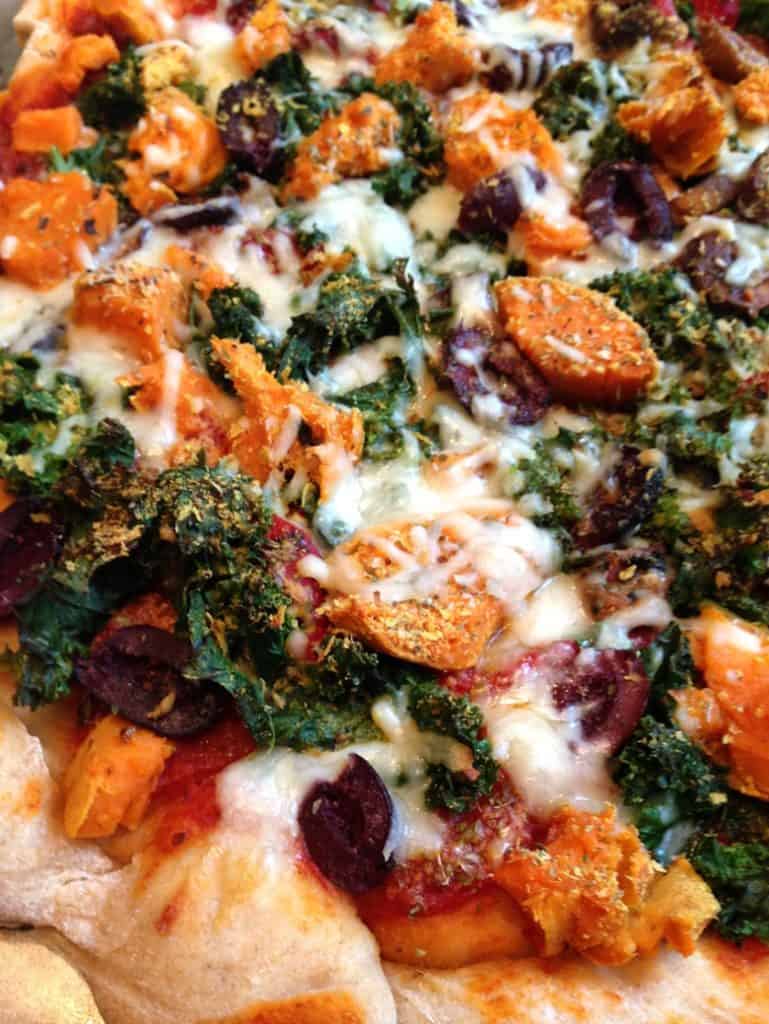 Closeup of sweet potato kale pizza with melted cheese | Bucket List Tummy