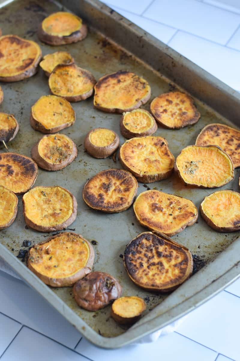 Sweet potato cut into coins roasted on baking sheet 