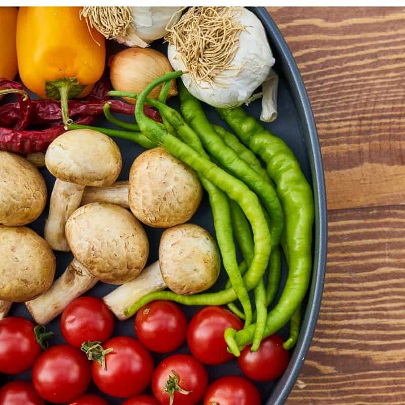 blue bowl of colorful veggies on wooden table