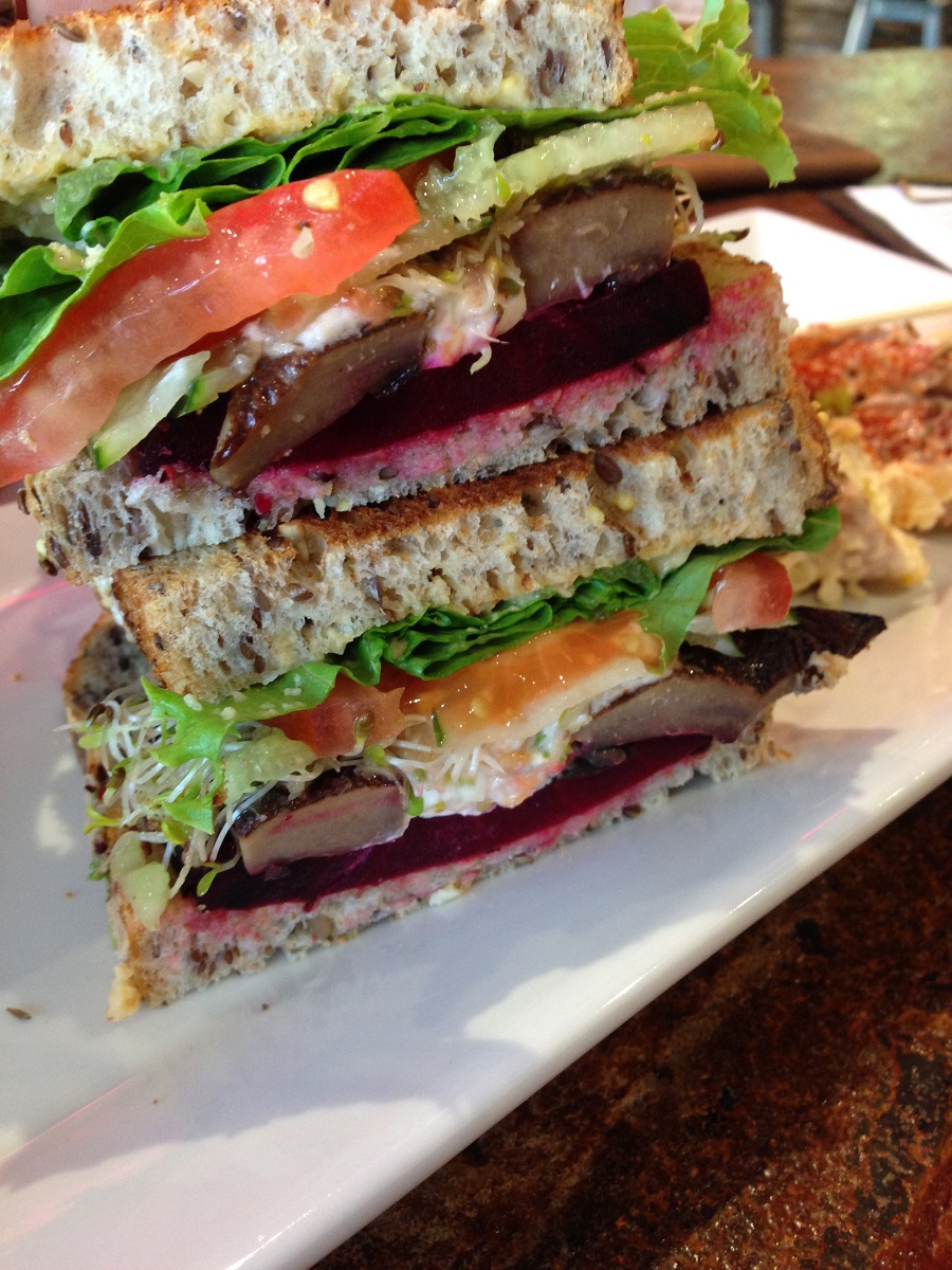 Vegetarian sandwich stacked on white serving plate