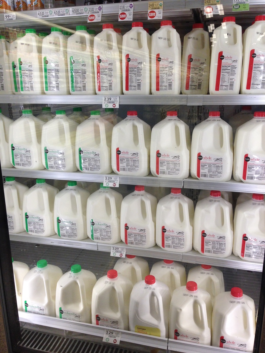 Grocery shelves with gallons of milk