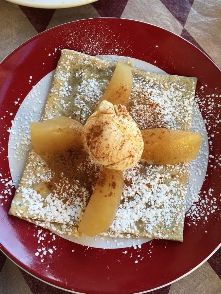 crepes with apples and ice cream on red plate