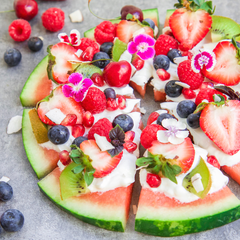 watermelon fruit pizza with whipped cream and topped with fresh fruit
