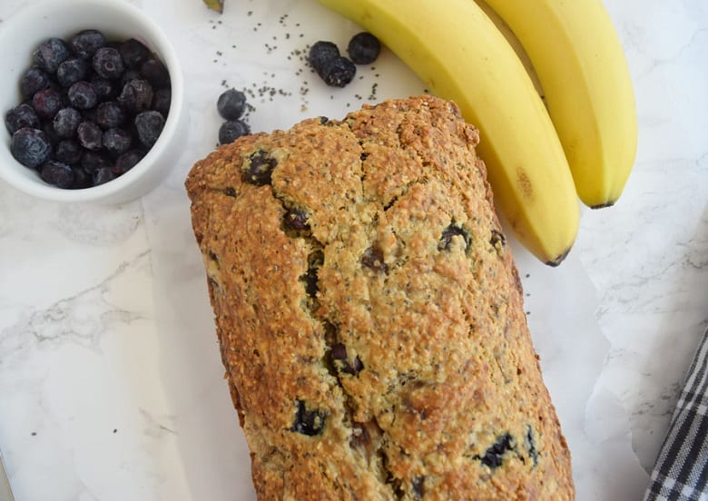 banana chia seed bread with frozen blueberries next to some bananas, chia seeds, and blueberries | Bucket List Tummy