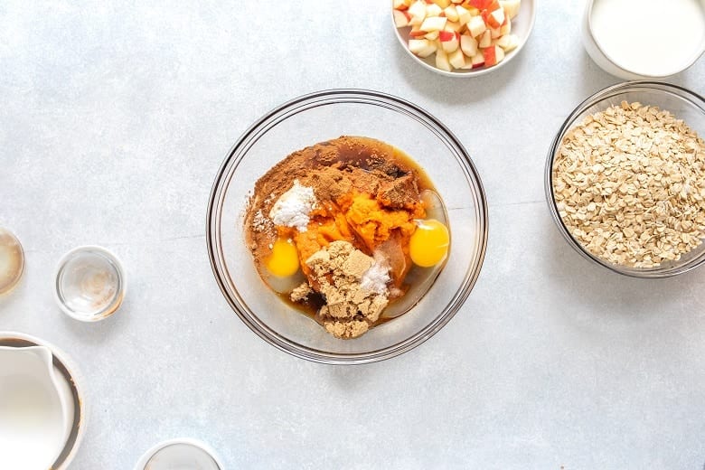 clear bowl with ingredients for pumpkin apple baked oats
