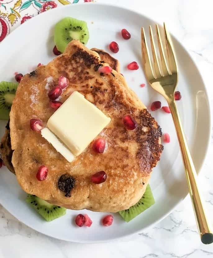 gingerbread protein pancakes with slab of butter and pomegranate aerils