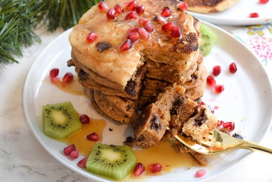 stack of whole wheat gingerbread protein pancakes with pomegranate seeds on top 