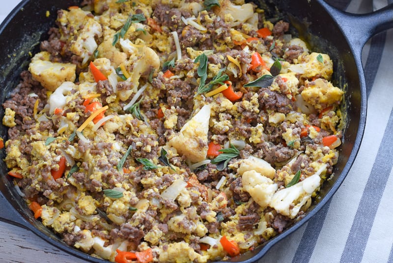 close up of breakfast scramble in skillet with beef, eggs and vegetables