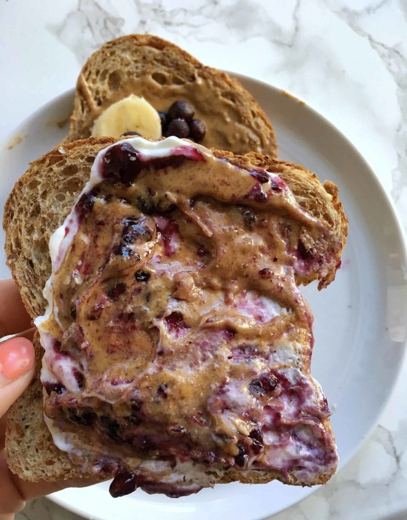white bowl with toast topped with yogurt, peanut butter and jelly