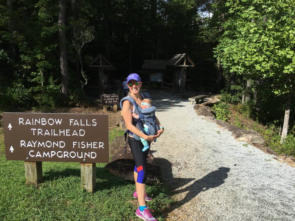 mom holding baby in ergo carrier before a hike