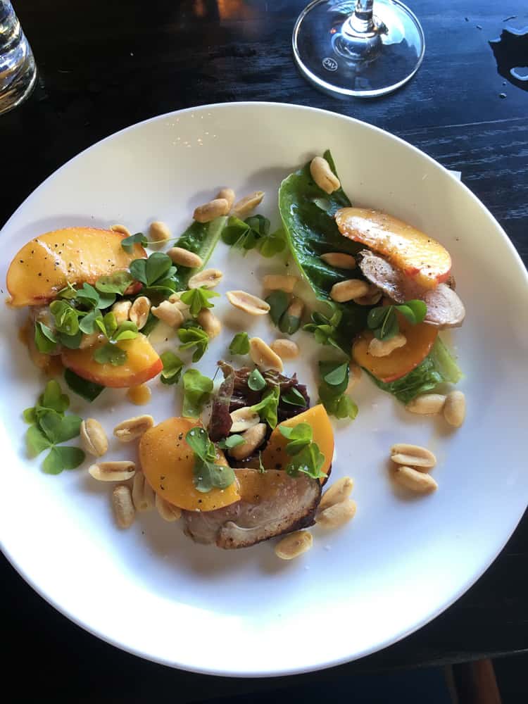 white plate with peach and peanuts on duck