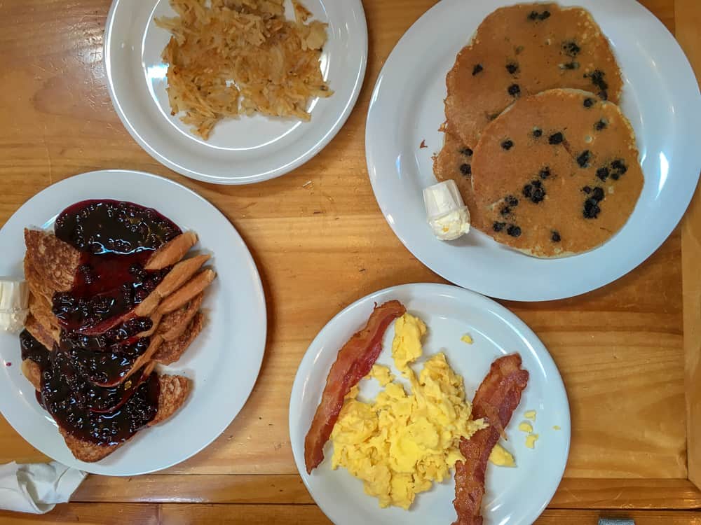 white plates with breakfast, pancakes and bacon