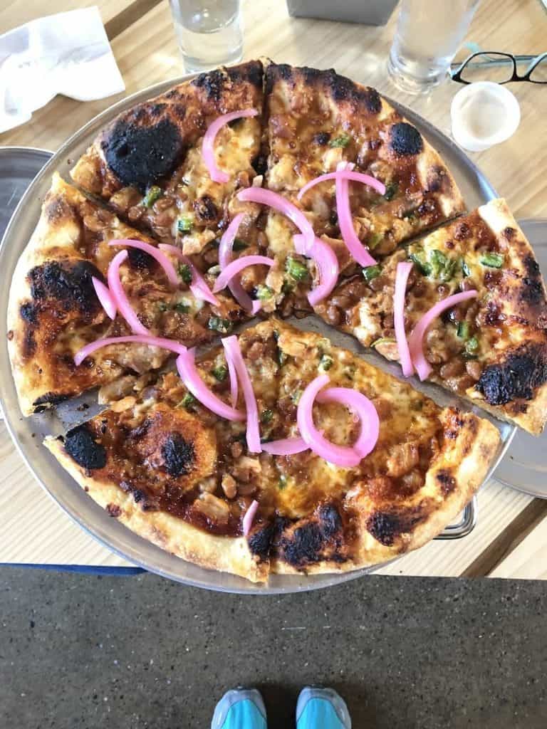 Detroit pizza on silver tray with red onions