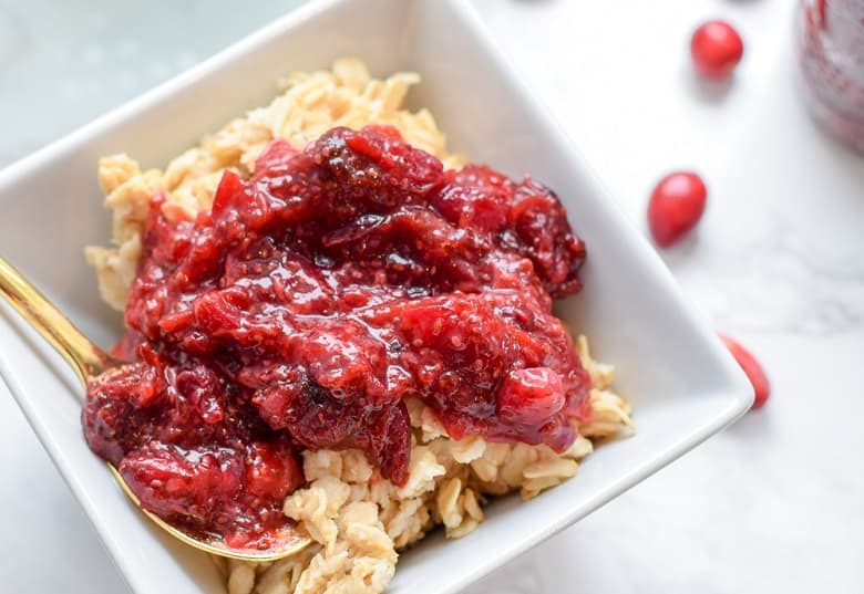 white bowl with oatmeal topped with homemade strawberry chia jam