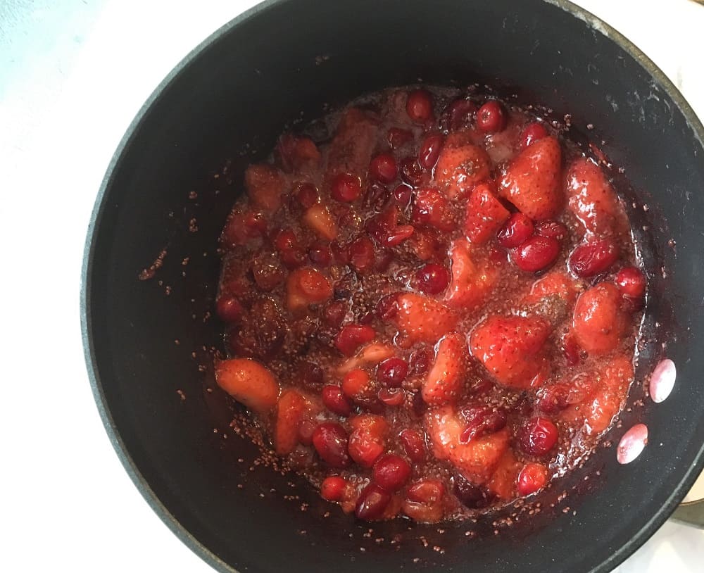 saucepan with cranberries, strawberries, chia seeds and water