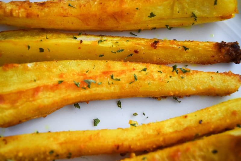 Close up of Roasted parsnip fries on a plate seasoned with garlic and turmeric | Bucket List Tummy