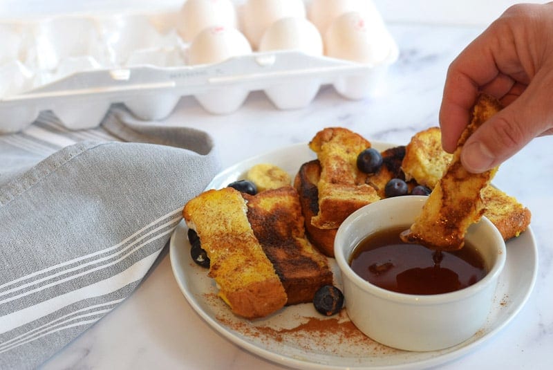 Dipping french toast sticks into syrup