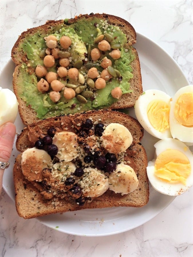 Chickpea toast with hardboiled eggs and toast with fruit on a white plate