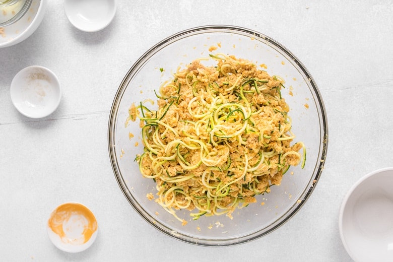 Mixing bowl with spiralized zucchini and canned salmon before cooking