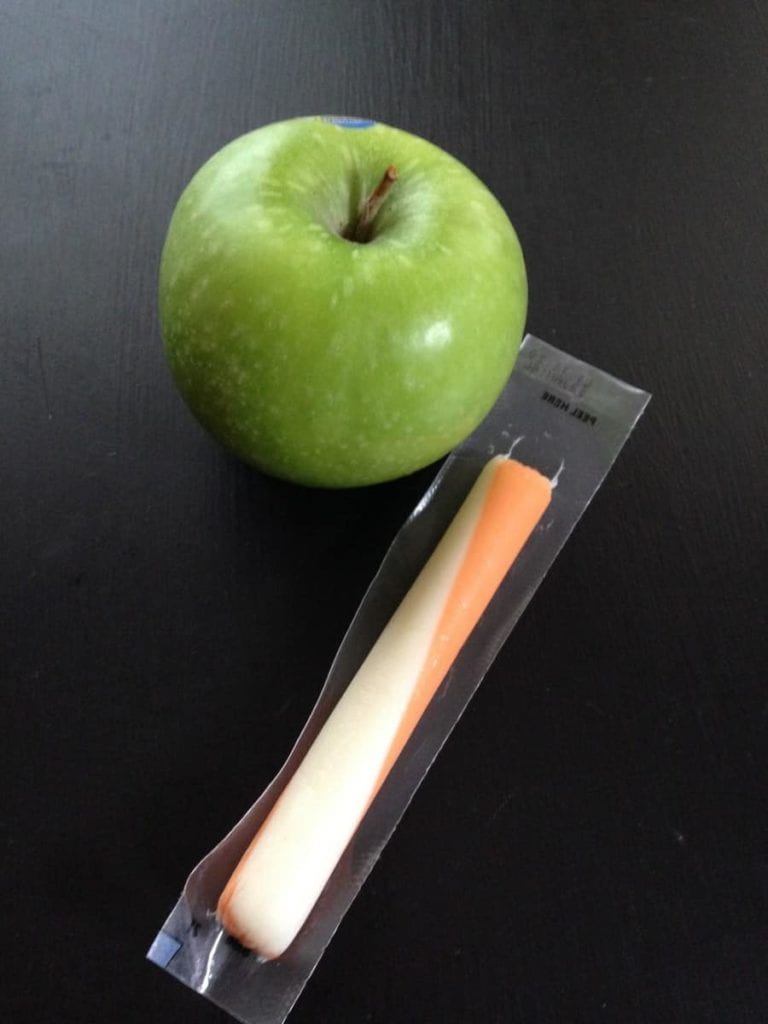 string cheese and green apple on black table