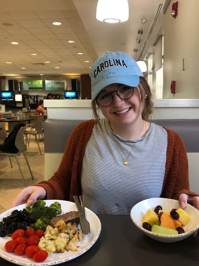 college student eating plates of food in a dining hall