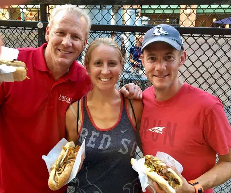 Father, daughter and husband enjoying sausages at Fenway Park