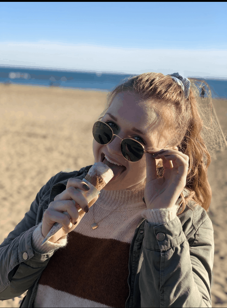 girl with sunglasses enjoying ice cream cone on the beach