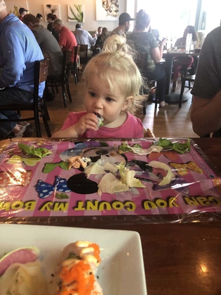 baby eating sushi out at a restaurant