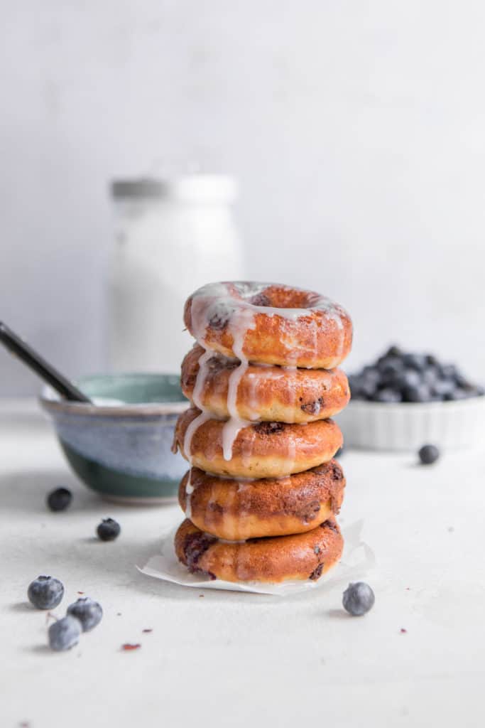 baked whole wheat donuts with blueberries stacked with vanilla icing