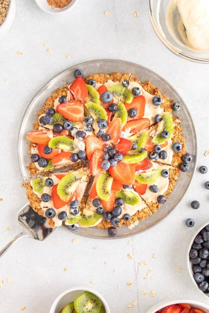 overhead final view of gluten free fruit pizza with greek yogurt frosting on pie plate | Bucket List Tummy