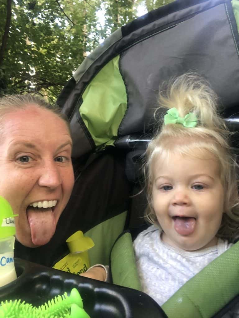 Sticking tongue out with daughter in stroller