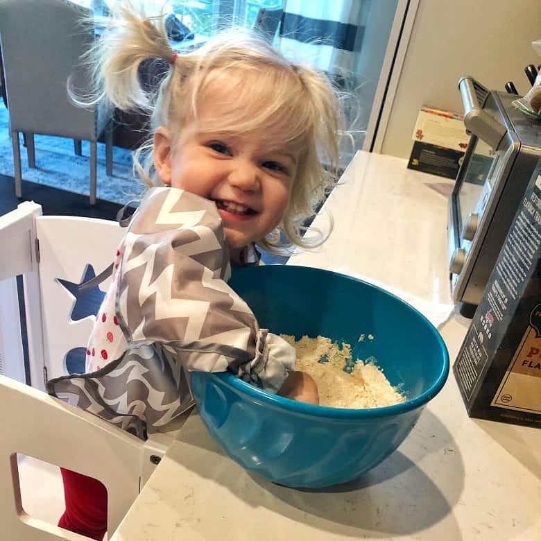toddler using mixing bowl in the kitchen