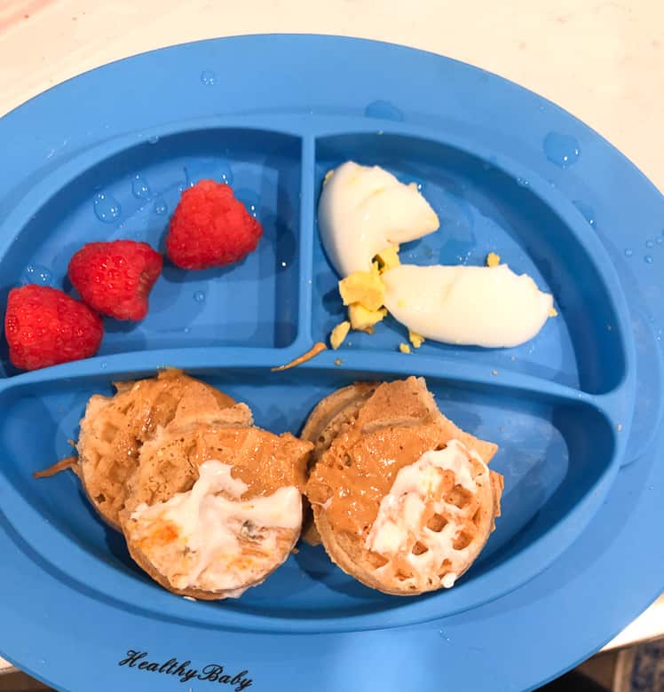 Toddler breakfast plate with mini waffles, berries and eggs