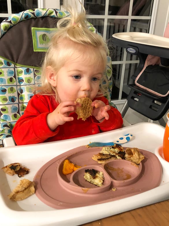Toddler eating waffles and pancakes with peanut butter