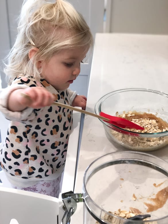 Toddler mixing muffins in kitchen helper