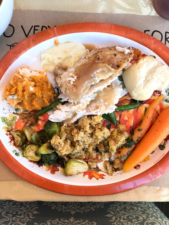 Thanksgiving plate filled with turkey, gravy, carrots, mashed potatoes and brussel sprouts