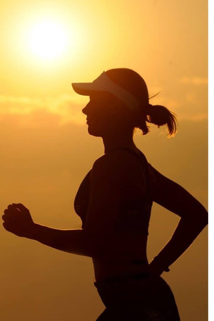 Woman running with sunrise in background
