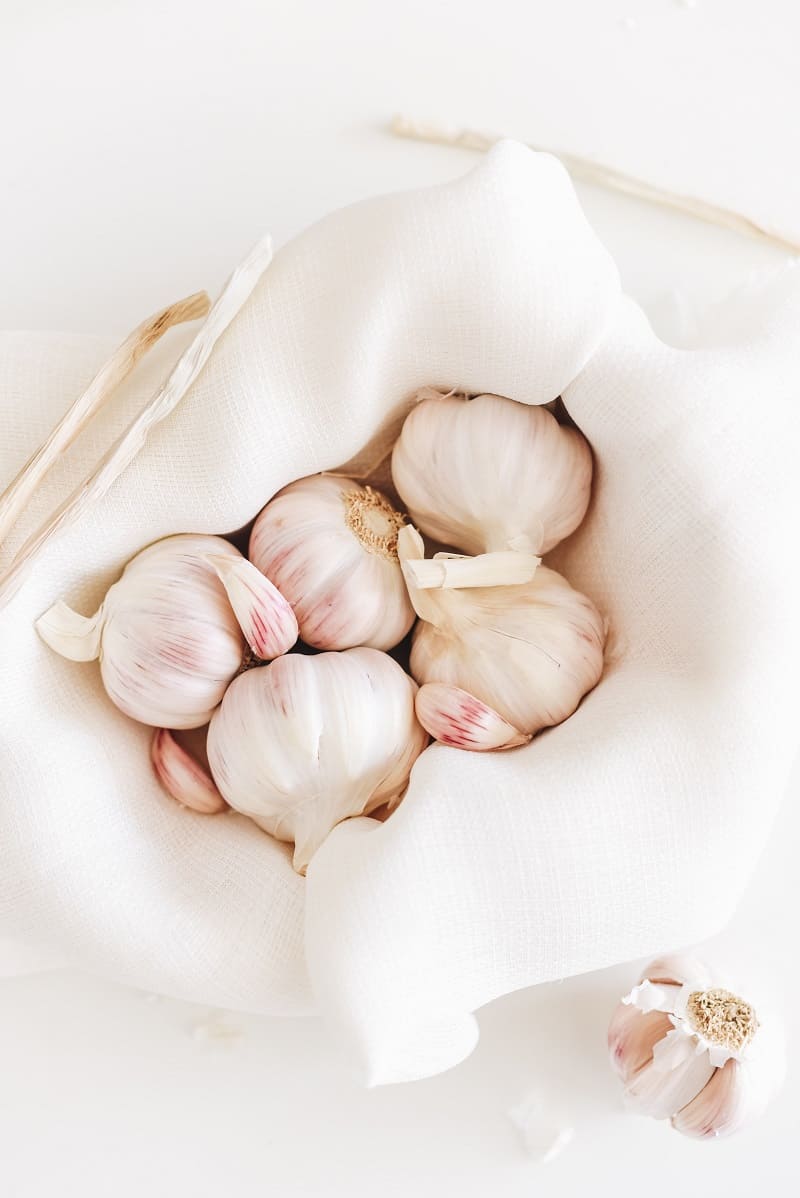 closeup of garlic cloves in white basket