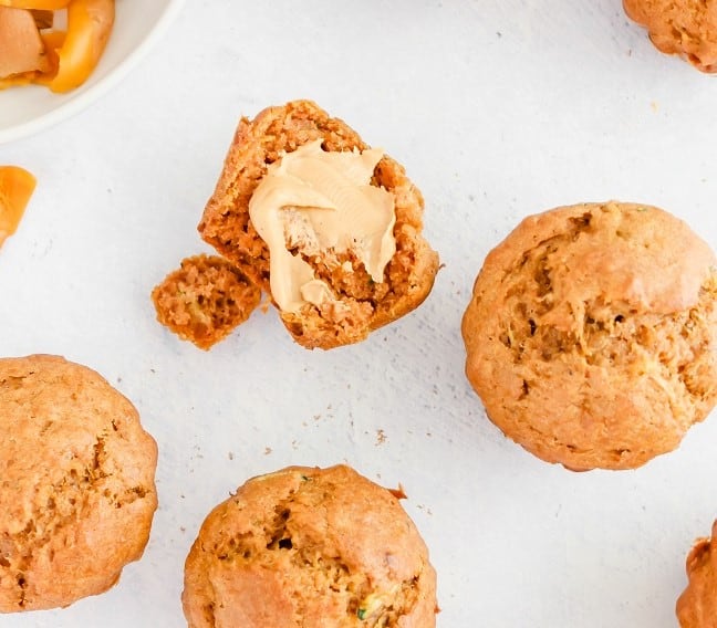 Zucchini sweet potato muffin recipe topped with peanut butter on white countertop