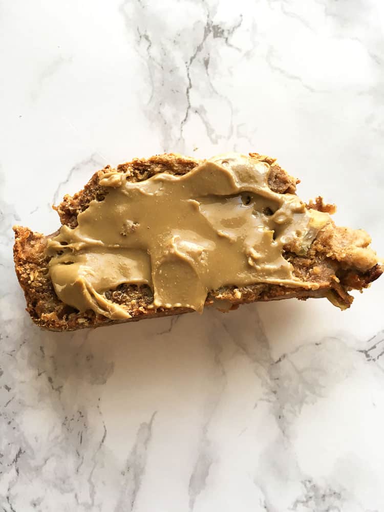 moist apple cinnamon bread piece with cinnamon peanut butter on white granite counter top 