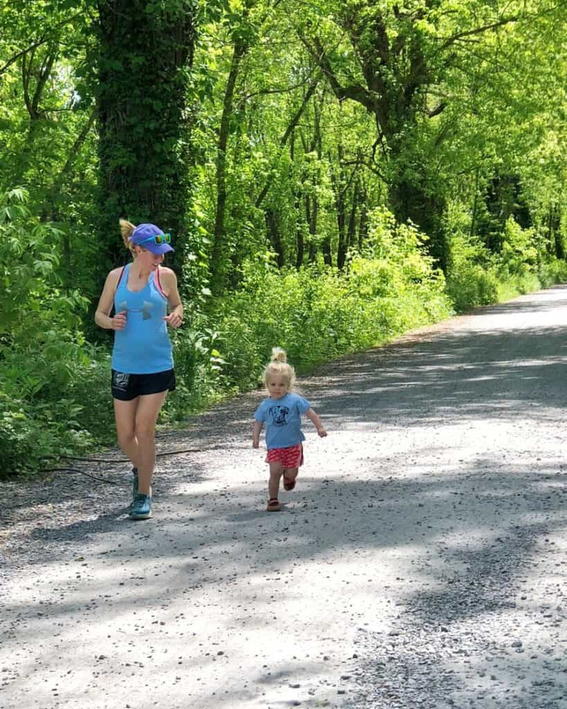 mom running on gravel path with daughter