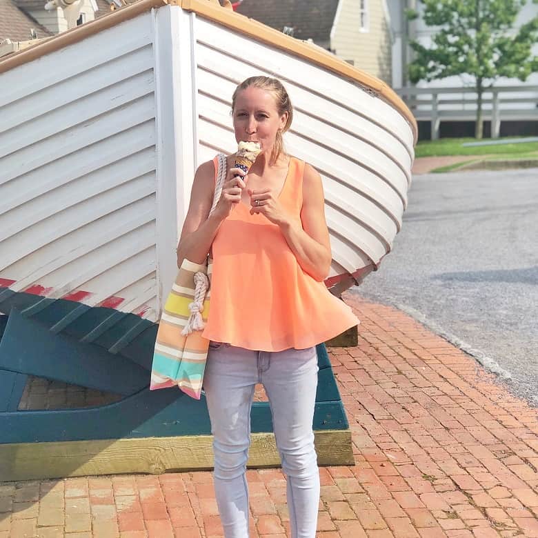 girl wearing orange tank top and eating ice cream