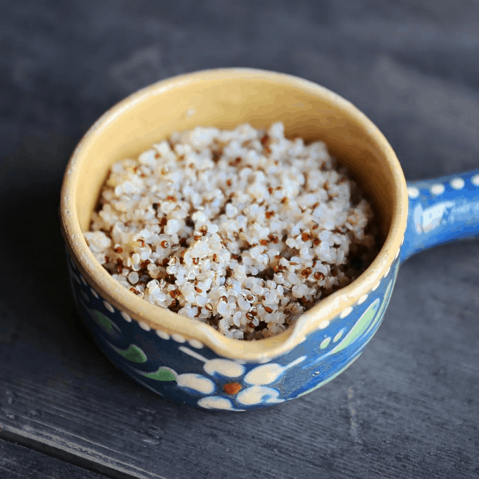cooked tri colored quinoa in blue serving bowl